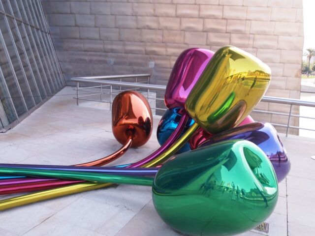 Jeff Koons: Tulipány, nehrdzavejúca oceľ s vysokým obsahom chrómu, 2 x 4,6 x 5,2 m. Zväzok siedmich tulipánov vyzerá ako gigantické lesklé balóny.