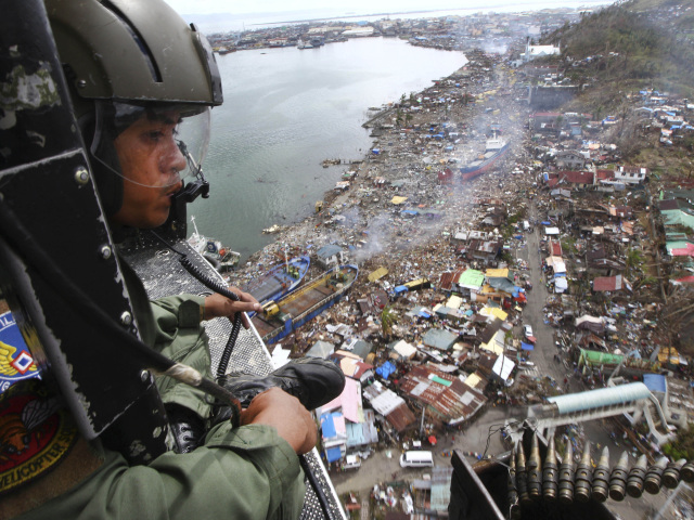 Filipínsky letec sa pozerá z vrtuľníka na mesto Tacloban, ktoré v novembri spustošil tajfún Haiyan. Azda najsilnejší tajfún v dejinách si len vo filipínskej provincii Leyte vyžiadal desaťtisíce obetí. Nárazy vetra dosahovali takmer 400 km/h, zabíjala však najmä voda.