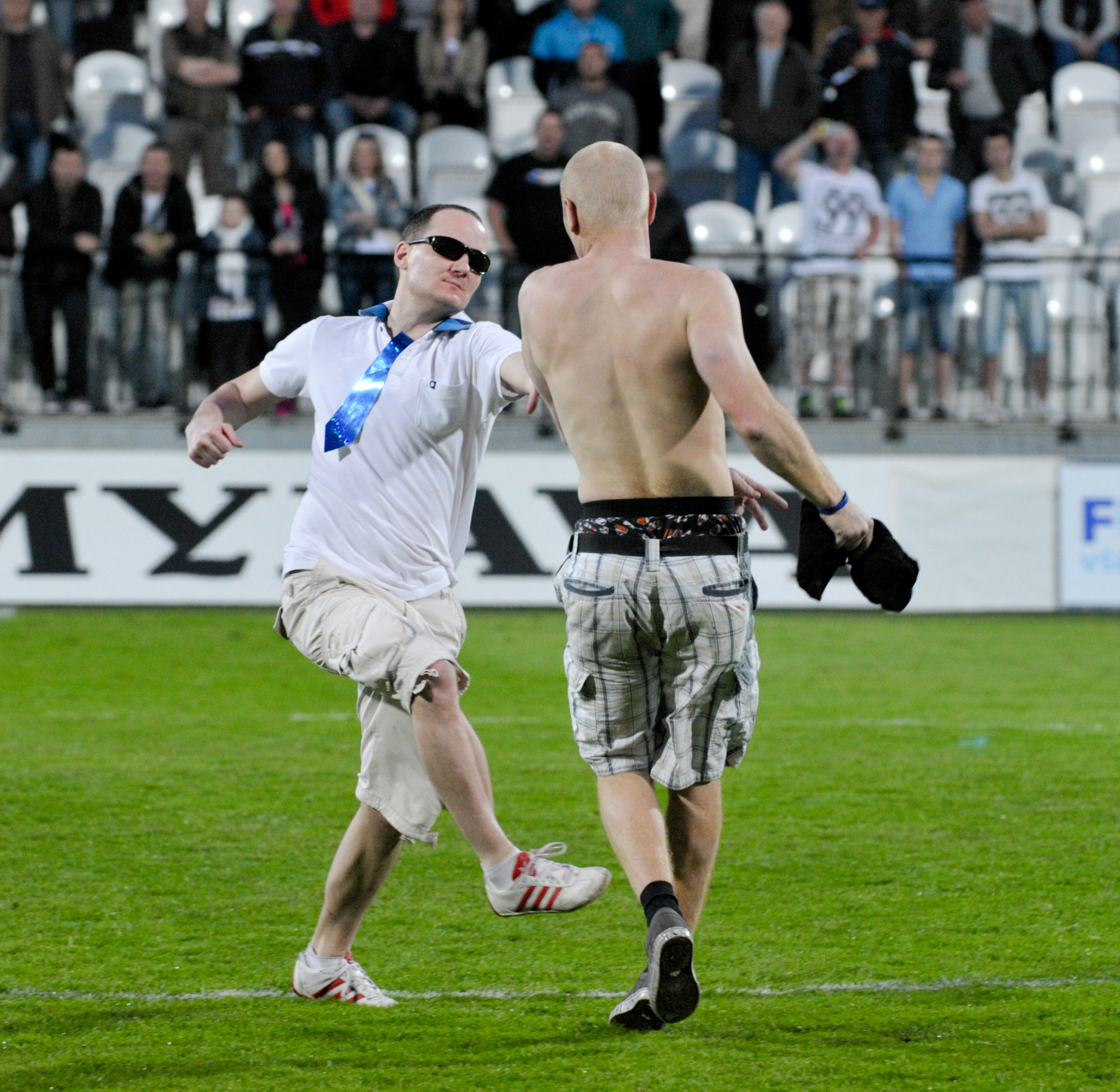 Fanúšik ŠK Slovan Bratislava (vľavo) a fanúšik MFK Košice (vpravo) na hracej ploche po skončení zápasu finále Slovnaft cup medzi ŠK Slovan Bratislava - MFK Košice.