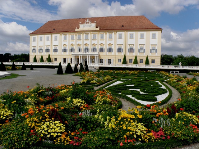 Východné priečelie zámku Hof obrátené na Slovensko s kvetinovými záhonmi.