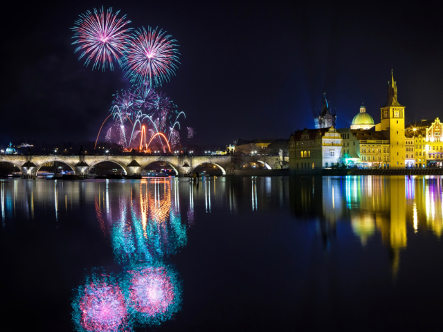 Atmosféra osláv Nového roka v Prahe je čarovná. Na fotografii ohňostroj nad Karlovým mostom s Pražským hradom v pozadí.