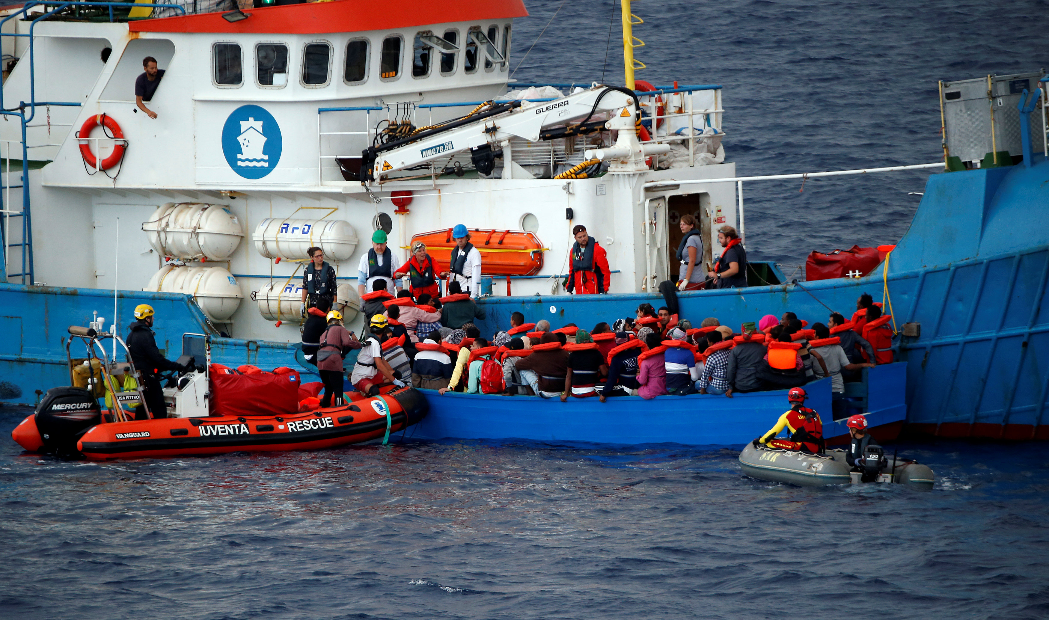 Záchranári z nemeckej mimovládnej organizácie Jugend Rettet na lodi Juventa
pomáhajú v blízkosti líbyjských brehov migrantom plaviacim sa na drevenej lodi.