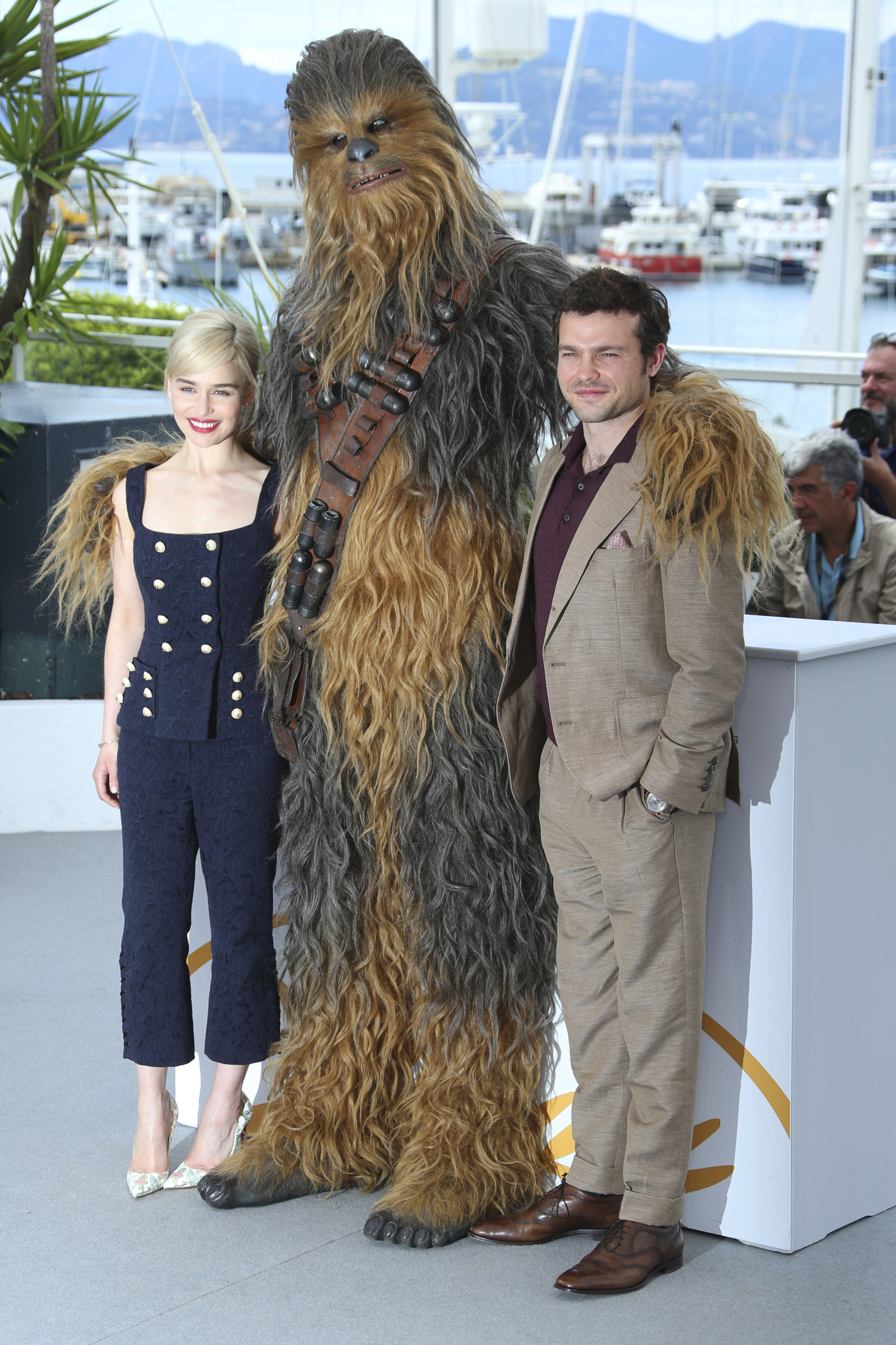 Herec Alden Ehrenreich, herečka Emilia Clarke (v komplete Dolce & Gabbana) a Chewbacca spoločne pózujú fotografom.
