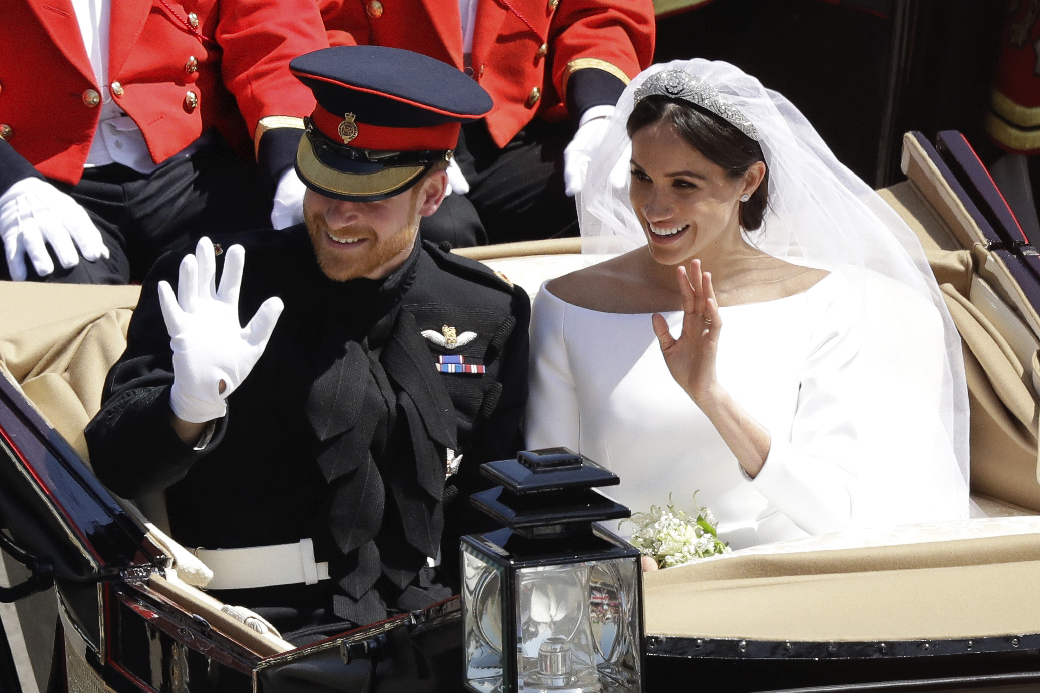 Mladomanželia, princ Harry a Meghan, sa vezú v koči ťahanom koŇmi po uliciach Windsoru.