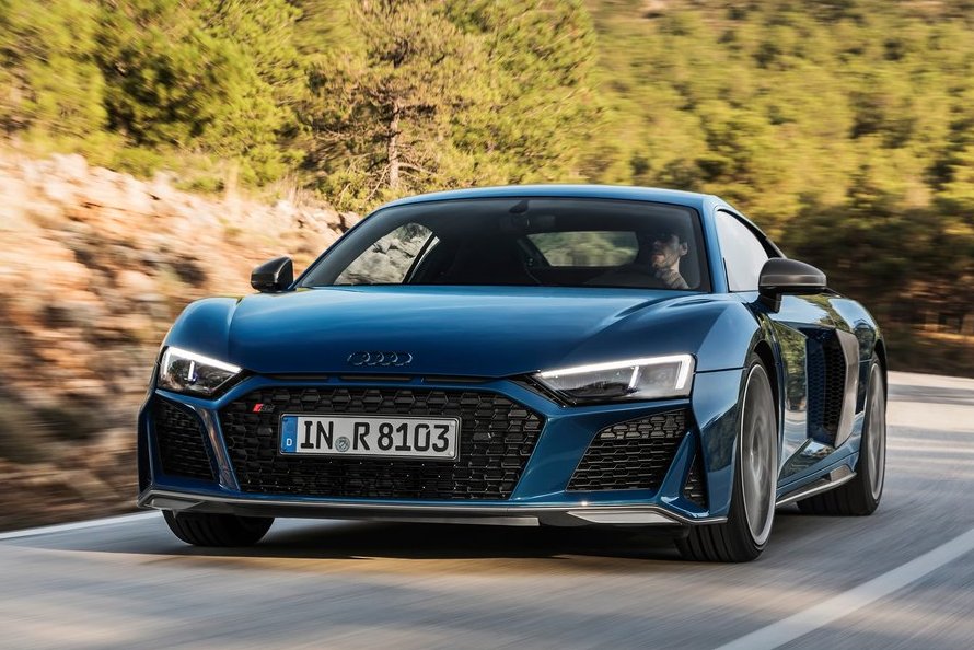 Audi R8 má ešte agresívnejší pohľad. To vďaka širšej čiernej maske a úplne prepracovanému nárazníku so zväčšenými otvormi pre prívod chladiaceho vzduchu. Nechýbajú ani tri úzke štrbinky pod kapotou ako odkaz na legendárne Audi Quattro.