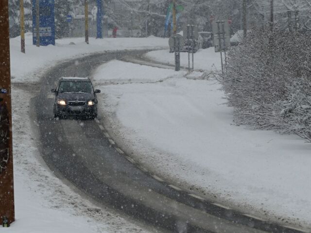 Zasnežená cestná komunikácia na sídlisku Vlčince v Žiline.
