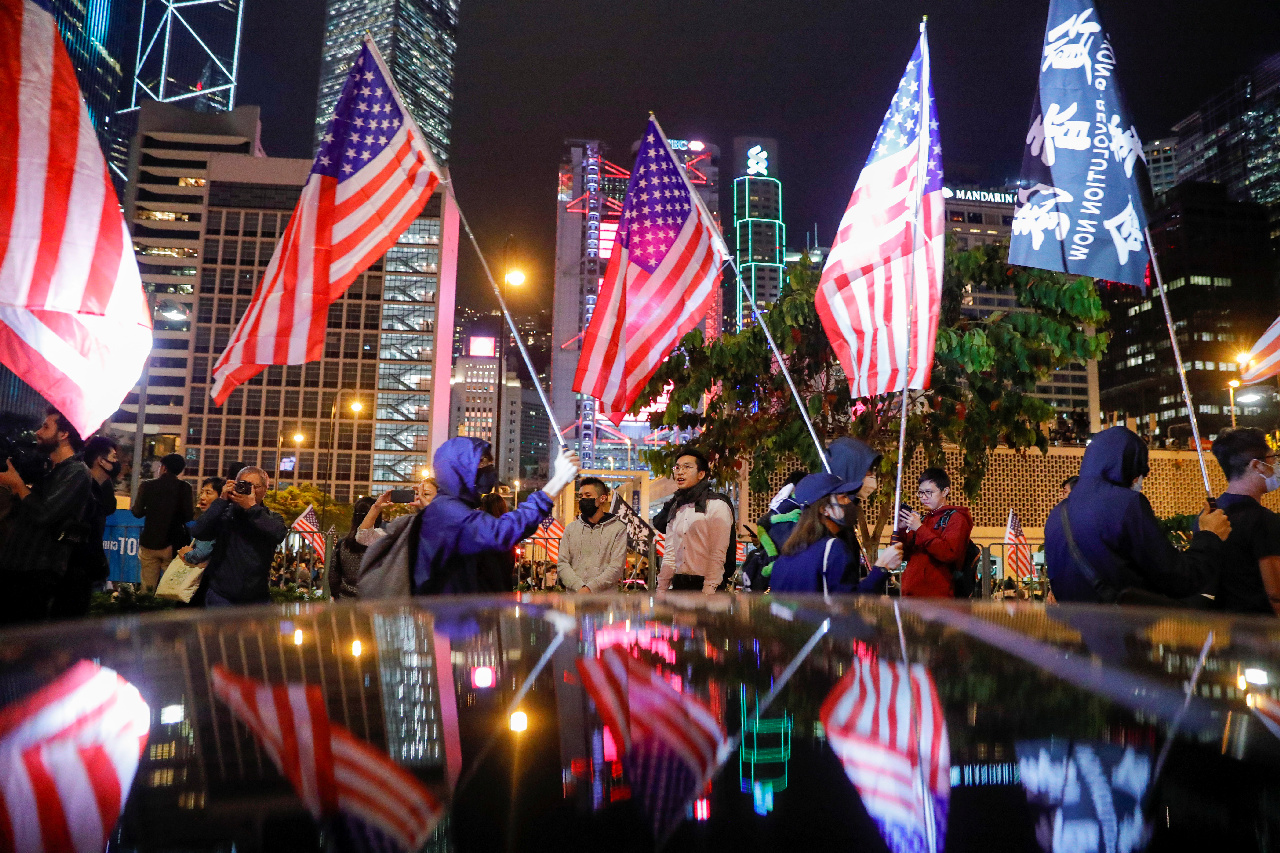 Protestujúci v Hongkongu s americkými vlajkami.