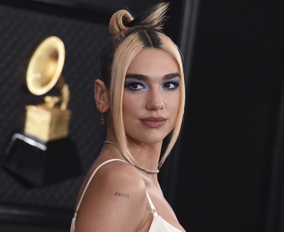 Speváčka Dua Lipa stavila pri výbere odevu na estetiku 90-tych rokov. A platilo to aj pri mejkape. Výrazné očné líčenie s modrými tónmi a bielym trblietavým tieňom vo vnútornom kútiku, k tomu pery zvýraznené kontúrovacou ceruzkou a tmavé odrasty korienkov vo vlasoch odfarbených na blond.