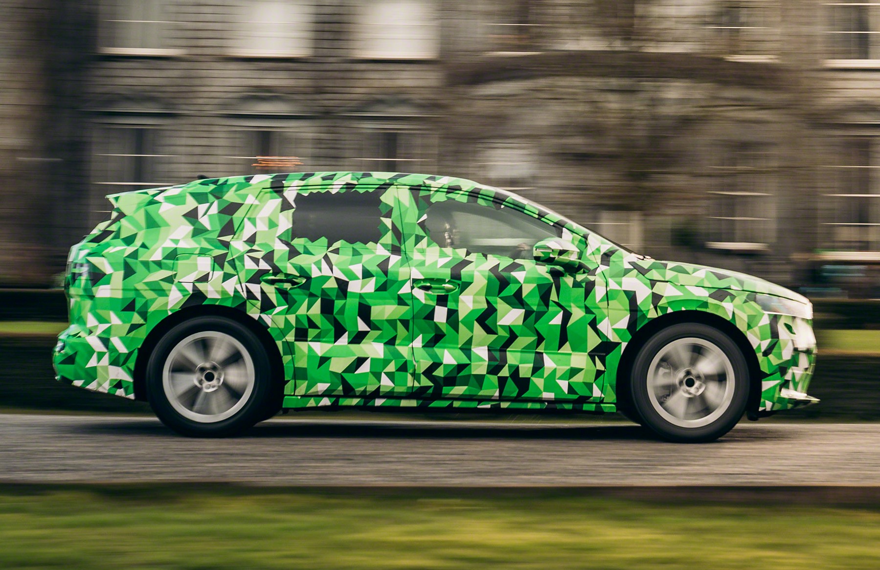 Prototypy vozidiel Škoda Enyaq iV aktuálne jazdia v zeleno-bielo-sivej kamufláži s trojrozmernými prvkami, ktoré rozostrujú dizajn. Uhádnuť výsledný tvar je naozaj ťažké.