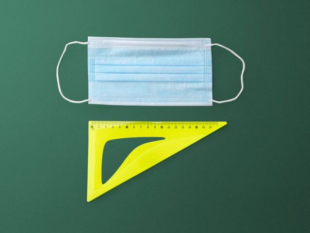 Flat lay top view of face mask and ruler, back to school and coronavirus concept.