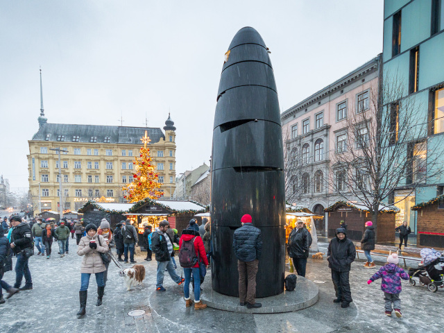 Kontroverzný objekt na náměstí Svobody v Brne je vysoký takmer 6 metrov a tvarom má pripomínať gigantický náboj. Každý deň o 11. hodine vypadne do jedného zo štyroch otvorov gulôčka, ktorú je možné odniesť si ako suvenír.