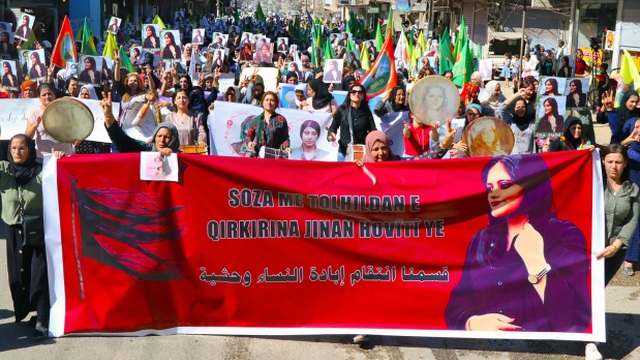 Kurdské ženy držia transparent s podobizňou 22-ročnej Iránky Mahsy Amíníovej počas protestu v meste Kámišlí na severovýchode Sýrie pri hraniciach s Tureckom 26. septembra 2022.