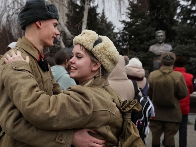 Mladý pár oblečený v historických frontových uniformách tancuje pri slávnostnom odhalení busty Stalina vo Volgograde.