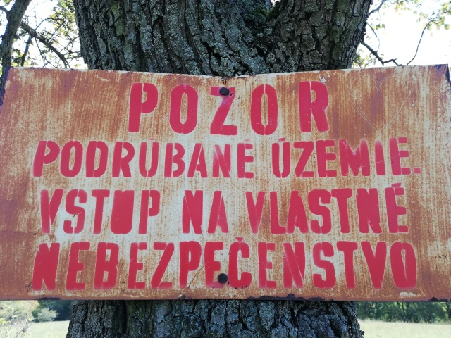 Tabuľa s upozornením vstupu na vlastné nebezpečenstvo, ktorá je pripevnená na strome neďaleko najnovšieho „kráteru“.