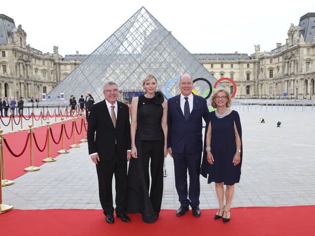 Thomas Bach (vľavo), monacká princezná Charlene v kreácii Alexander McQueen a s kabelkou Louis Vuitton, knieža Albert II. a Claudia Bach
