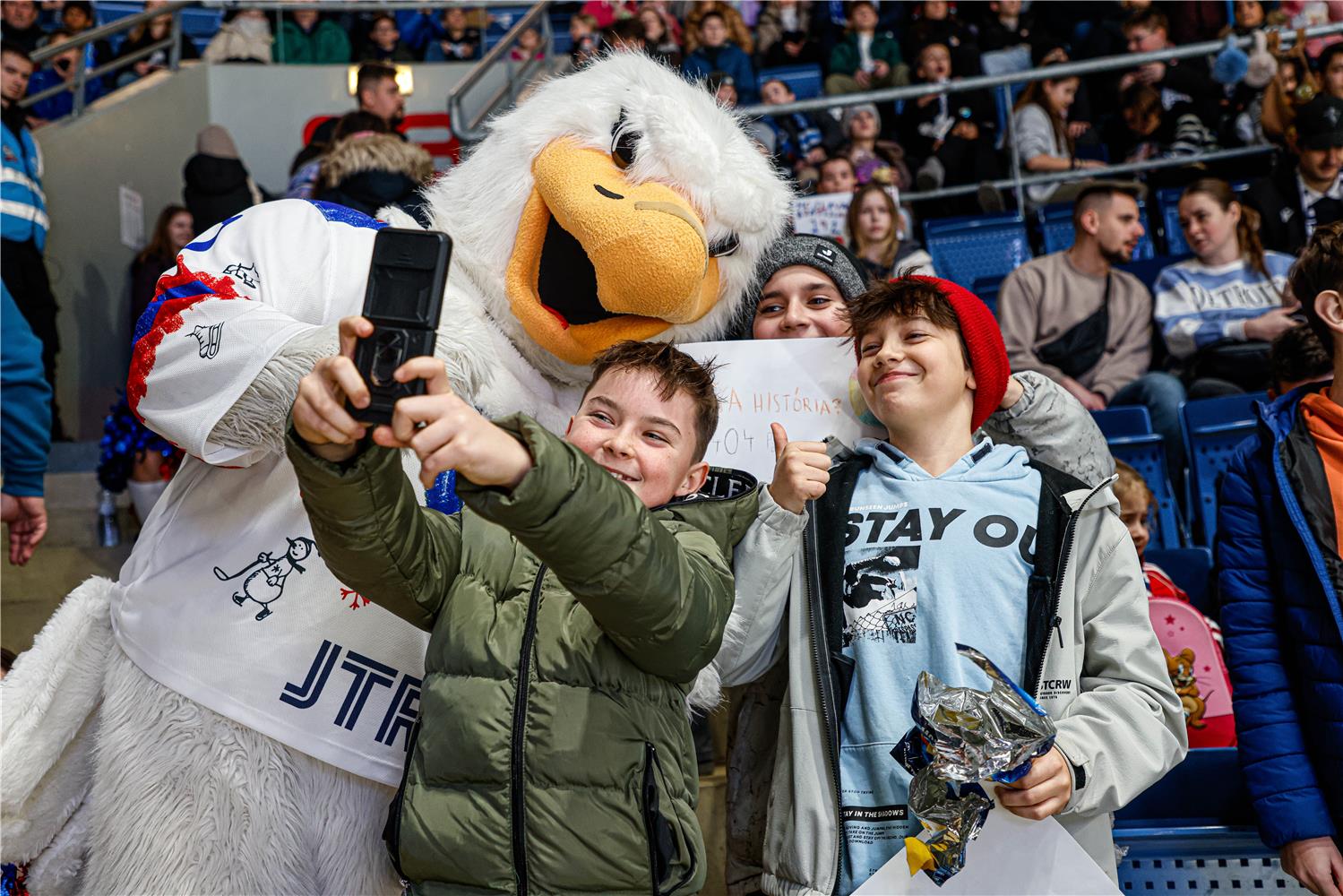 Maskot HC Slovan Harvy s fanúšikmi.